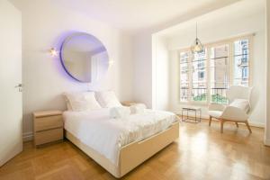 a white bedroom with a large bed and a mirror at Spacieux 3 Pièces de standing au centre de Monaco in Monte Carlo