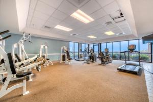 een fitnessruimte met loopbanden, crosstrainers en fitnessapparatuur in een gebouw bij Phoenix II in Orange Beach