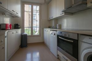 a kitchen with white appliances and a window at Spacieux 3 Pièces de standing au centre de Monaco in Monte Carlo