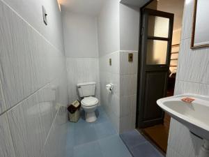 een witte badkamer met een toilet en een wastafel bij Tanguitos in Sucre