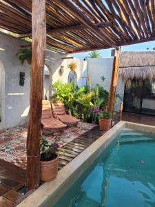 a patio with chairs and a swimming pool at Puerto del Cielo in Chuburná