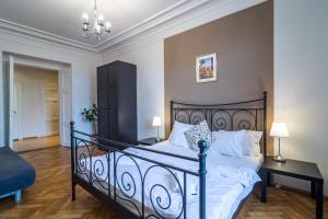 a bedroom with a black bed with white pillows at Royal Road Residence in Prague