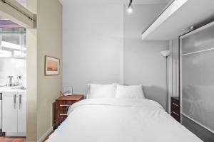 a bedroom with a white bed and a sink at Jukebox Olympic View by Iris Properties in Victoria