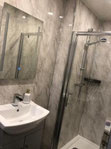 uma casa de banho com um chuveiro e um lavatório. em Ashfield Hotel em Huddersfield