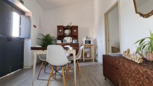 a living room with a table and white chairs at Monte da ti Luzia in Faro