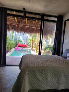 a bedroom with a bed and a swimming pool at Puerto del Cielo in Chuburná