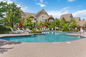 a swimming pool with chairs and a house at Contemporary Chalet Steps to Blue Mountain Village in Blue Mountains