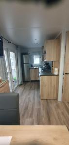 uma cozinha com pisos em madeira e uma cozinha com um frigorífico em MH 476 annexe Bois Dormant em Saint-Jean-de-Monts