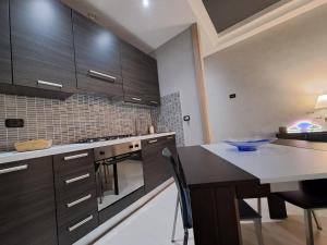 a kitchen with wooden cabinets and a table with chairs at Appartamento nel cuore di Parma - Laterale via Farini in Parma