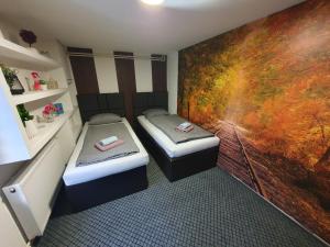 two beds in a room with a painting on the wall at Apartments Arna in Visoko