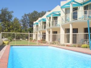 a house with a swimming pool in front of a house at Bayview Apartments in Merimbula