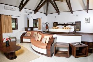 um quarto amplo com 2 camas e um sofá em Ravintsara Wellness Hotel em Ambaro