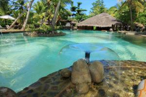 a swimming pool at a resort with a fountain at Ravintsara Wellness Hotel in Ambaro
