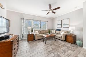 uma sala de estar com um sofá e uma ventoinha de tecto em GulfShores BeachCondo - Pool - FreeParking - SummerTime! - Little Lagoon em Gulf Shores
