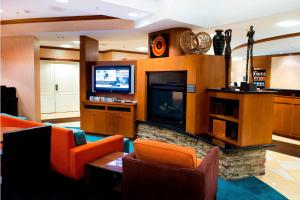 sala de estar con sillas de color naranja y TV de pantalla plana en Residence Inn by Marriott Toronto Vaughan, en Vaughan