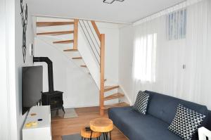 ein Wohnzimmer mit einem blauen Sofa und einer Treppe in der Unterkunft Domek nad wodą Liliput in Jelenia Góra