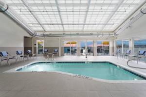 a swimming pool in a building with chairs and a table at Fairfield Inn & Suites by Marriott Ocean City in Ocean City