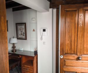 Zimmer mit einem Schreibtisch und einer Holztür in der Unterkunft Apartamentos en pleno centro, Aljibe Rodrigo del Campo 2A in Granada