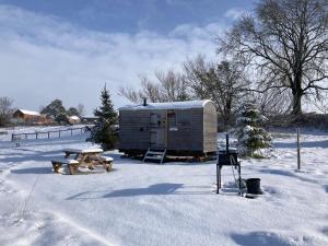 um reboque e uma mesa de piquenique na neve em The Shepherd's Hut with cosy logburner em Wrexham
