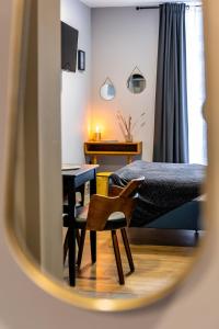 Schlafzimmer mit einem Bett, einem Schreibtisch und einem Stuhl in der Unterkunft Escapade Place 11 - N2 Studio - Dinan centre in Dinan