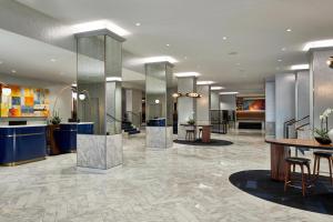 a lobby of a hotel with tables and chairs at Le Méridien St. Louis Clayton in Clayton