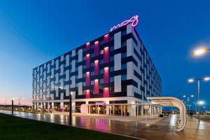 ein Gebäude mit einem Neonschild darüber in der Unterkunft MOXY Vienna Airport in Schwechat