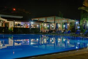 a swimming pool at night with a gazebo at Hylatio Tourist Village in Pissouri