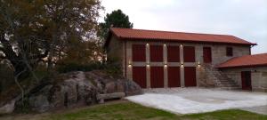 ein rotes Gebäude mit einem großen Felsen davor in der Unterkunft Quinta Pousada de Fora in Guimarães