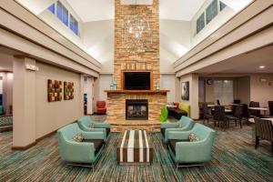 a lobby with a fireplace and couches and a tv at Residence Inn Chicago Midway Airport in Bedford Park