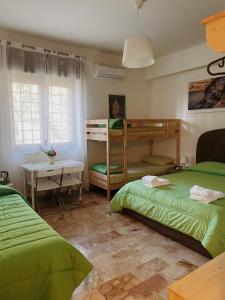a bedroom with two beds and a table and a desk at L'Anfiteatro di Pompei B&B in Pompei