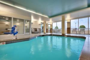 a large swimming pool with blue water in a building at Fairfield Inn & Suites by Marriott Springfield North in Springfield