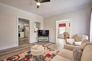 a living room with a couch and a tv at Dog-Friendly Downtown Auburn Vacation Rental! in Auburn