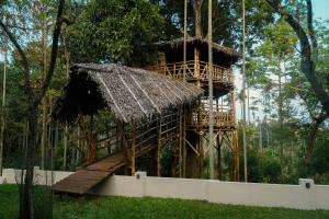 a tree house in the middle of a forest at VanaJyotsna Forest Home in Maraiyūr