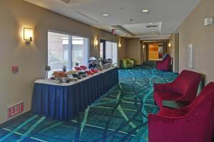 eine Lobby mit roten Stühlen und einem Tisch in einem Zimmer in der Unterkunft SpringHill Suites by Marriott Dallas DFW Airport East Las Colinas Irving in Irving