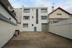 an empty parking lot in front of a white building at escale-marne fr - 21 - Appartement entier, 4 pers, 10mn metro 8, RER A, Parking rue Gratuit, Grand Matelas Emma, Cuisine Équipée, Vue panoramique, 2ème étage in Maisons-Alfort