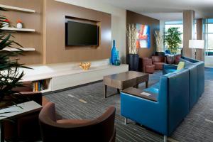 a living room with a blue couch and a tv at Courtyard by Marriott Knoxville West/Bearden in Knoxville