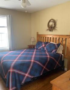 a bedroom with a bed with a plaid blanket at Whispering Waves Cottages in Shelburne