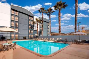 a hotel with a swimming pool and palm trees at Courtyard Vallejo Napa Valley in Vallejo