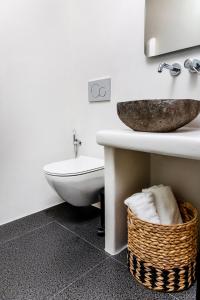 uma casa de banho com um lavatório, um WC e uma cesta. em Alenor City Hotel em Naxos Chora