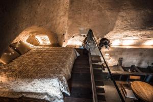 Camera con letto e scale in una grotta di SUITE LA STALLA a Matera