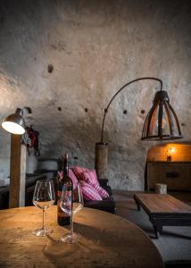 un tavolo con due bicchieri da vino sopra di SUITE LA STALLA a Matera