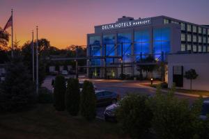 a building with a car parked in a parking lot at Delta Hotels by Marriott Milwaukee Northwest in Menomonee Falls