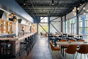 een restaurant met tafels, stoelen en ramen bij Delta Hotels by Marriott Milwaukee Northwest in Menomonee Falls