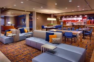 a hotel lobby with couches and tables and a restaurant at Courtyard by Marriott Lehi at Thanksgiving Point in Lehi