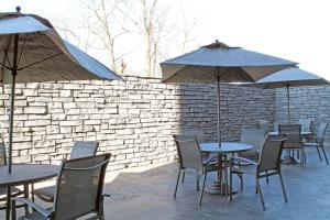 un groupe de tables et de chaises avec parasols dans l'établissement Fairfield by Marriott Inn & Suites St Louis South, à Saint-Louis