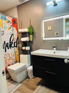 a bathroom with a sink and a toilet and a mirror at Tropical Casita in Tampa near airport and Raymond James stadium in Tampa