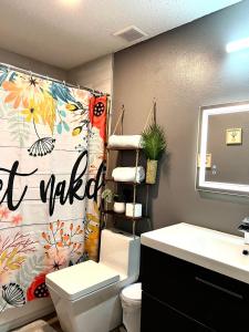a bathroom with a toilet and a shower curtain at Tropical Casita in Tampa near airport and Raymond James stadium in Tampa