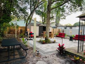 un patio con sillas rojas y un árbol en Tropical Casita in Tampa near airport and Raymond James stadium en Tampa