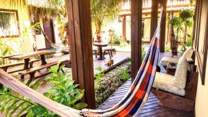 a porch with a hammock and a dog sitting in it at Home suíte taipu in Marau