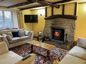 a living room with couches and a stone fireplace at Sweet Knoll Farm in Peak Forest